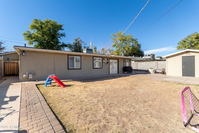 view of front facade with a patio area, french doors, and a storage unit