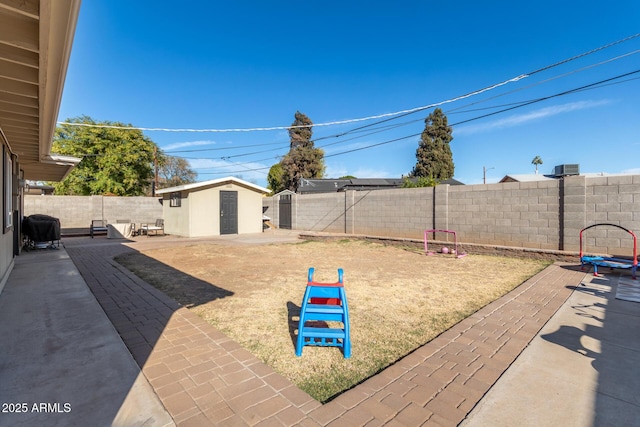 view of yard with a storage shed and a patio