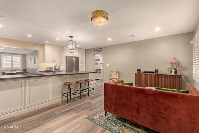 living room featuring a chandelier and light hardwood / wood-style flooring