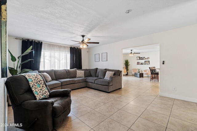 tiled living room with ceiling fan and a textured ceiling