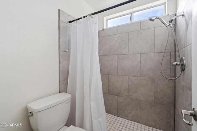 bathroom with a shower with shower curtain and toilet