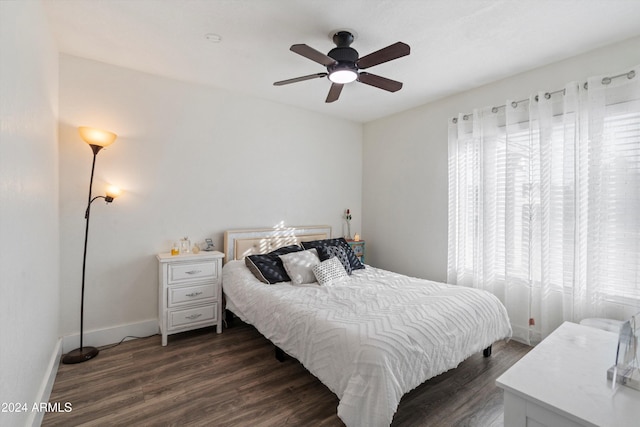 bedroom with ceiling fan, dark hardwood / wood-style flooring, and multiple windows