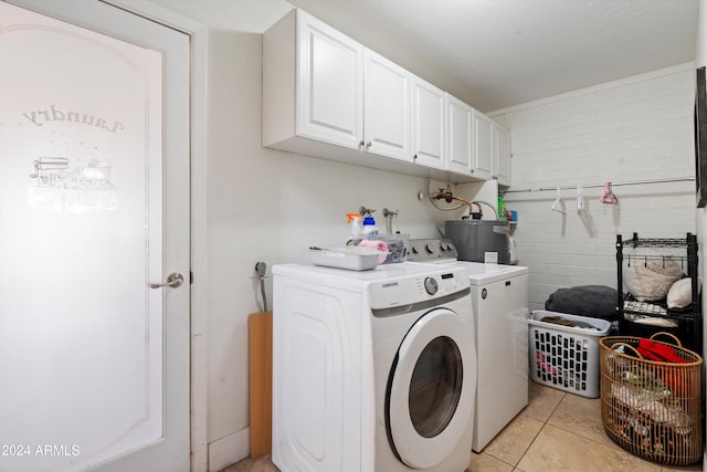 laundry room with washer and clothes dryer, light tile patterned flooring, cabinets, and electric water heater