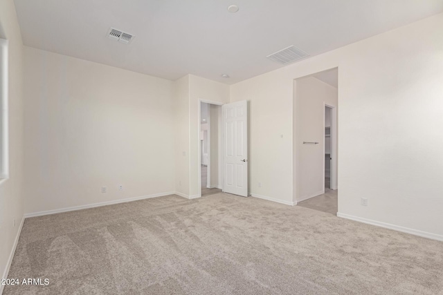 unfurnished room featuring light carpet