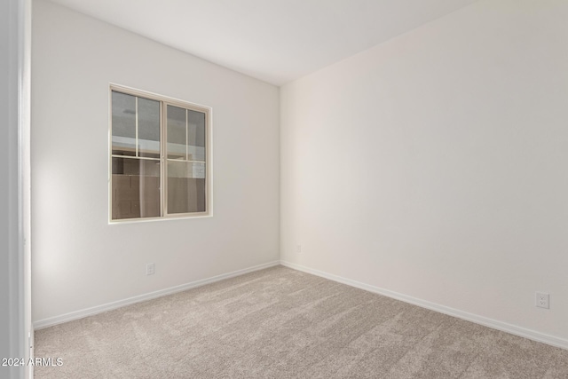 unfurnished room featuring light carpet