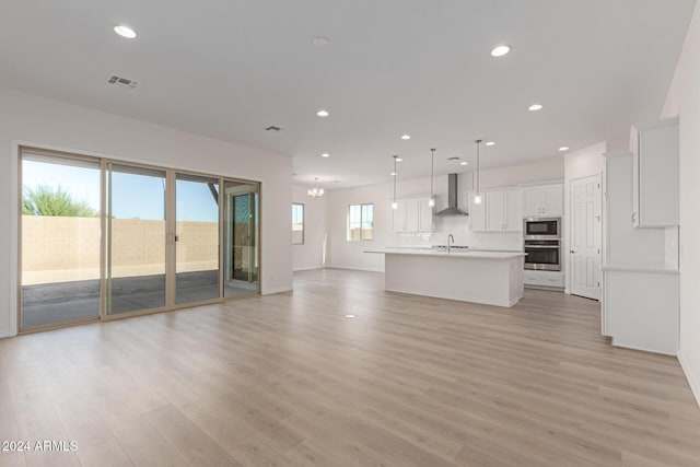 unfurnished living room with a wealth of natural light, sink, and light wood-type flooring