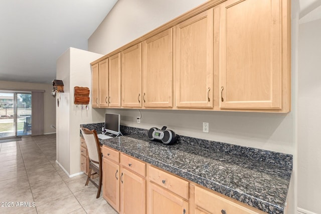 kitchen featuring light brown cabinetry, built in desk, tile countertops, light tile patterned floors, and baseboards