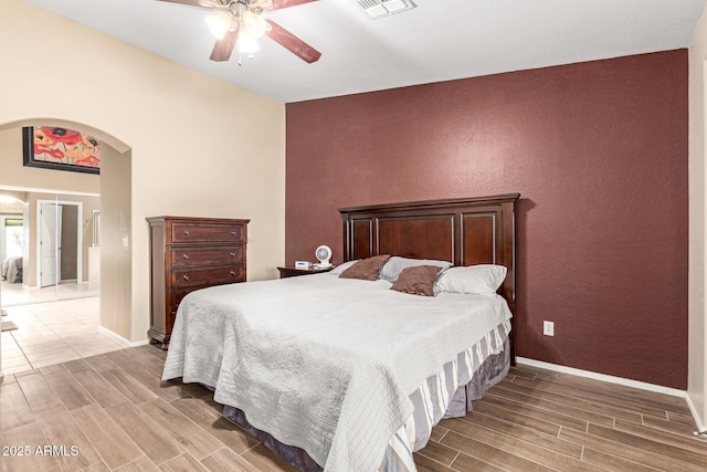 bedroom with visible vents, arched walkways, baseboards, and wood tiled floor