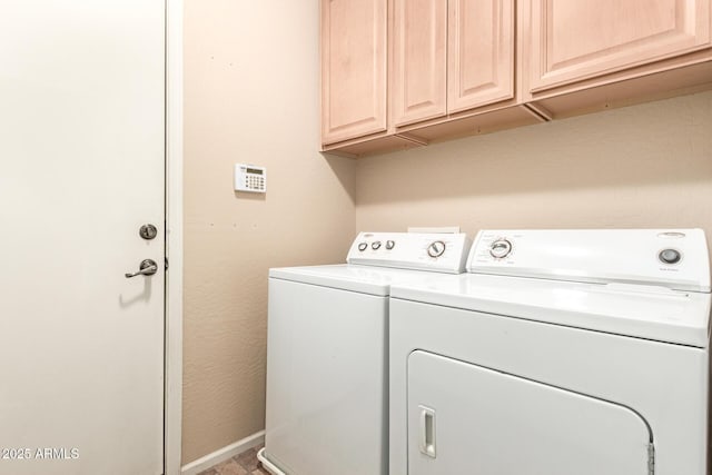 laundry room with washer and clothes dryer, cabinet space, and baseboards