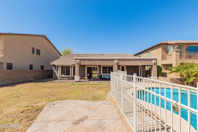 back of property with a fenced in pool, fence, an attached garage, a patio area, and a lawn