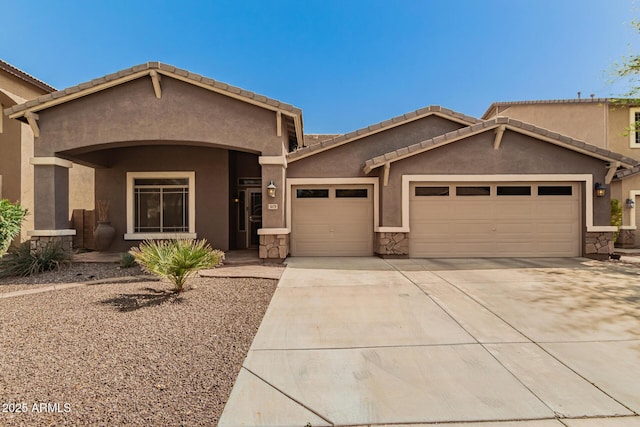 view of front of home with a tile roof, a garage, driveway, and stucco siding