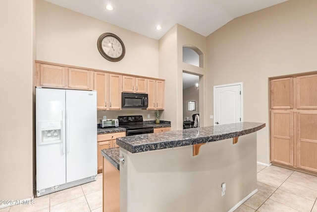 kitchen with light brown cabinets, tile countertops, a breakfast bar area, light tile patterned floors, and black appliances