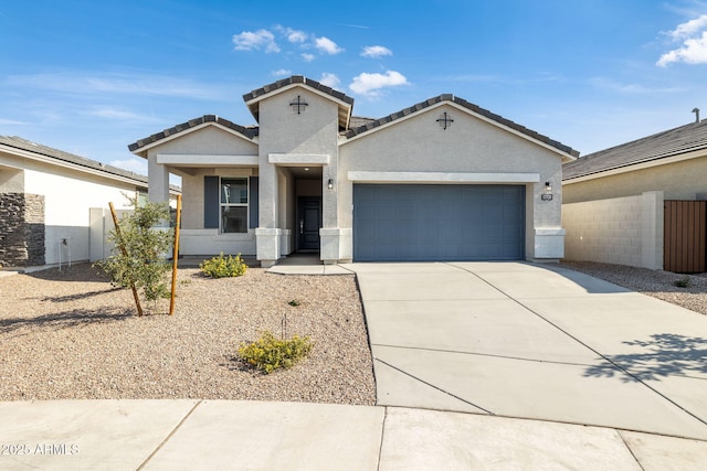 view of front of house with a garage, concrete driveway, a tile roof, and stucco siding