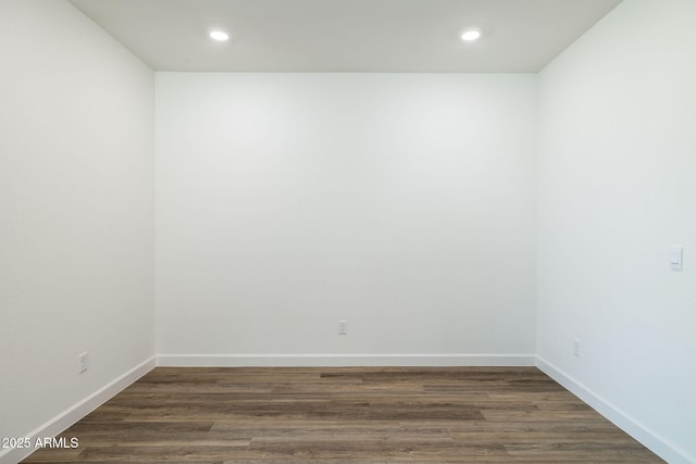 empty room featuring baseboards, dark wood-type flooring, and recessed lighting