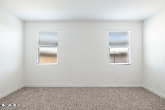 empty room with light carpet, baseboards, and a healthy amount of sunlight