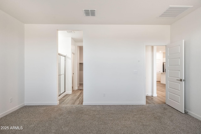 unfurnished room with carpet floors, baseboards, and visible vents