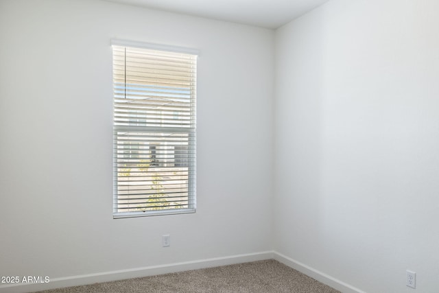 carpeted spare room featuring baseboards