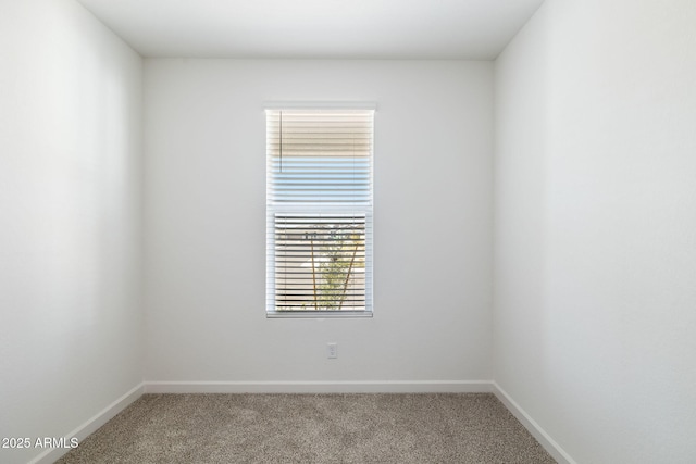 carpeted spare room featuring baseboards