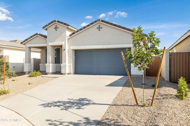 view of front of home with a garage, concrete driveway, a tile roof, fence, and stucco siding