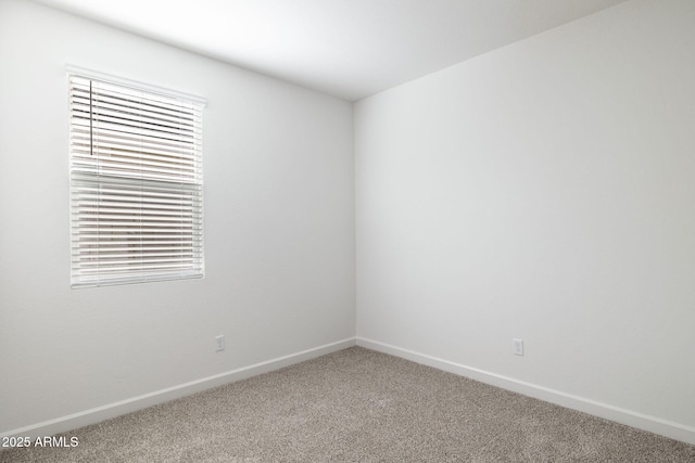 unfurnished room with carpet and baseboards