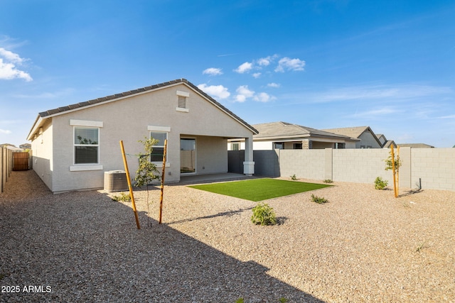 rear view of house featuring a fenced backyard, a patio area, cooling unit, and stucco siding