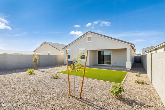 rear view of house featuring a patio, cooling unit, a fenced backyard, a lawn, and stucco siding