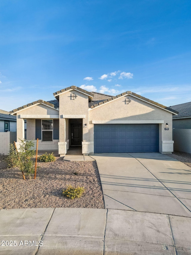 view of front of property featuring an attached garage, concrete driveway, and stucco siding