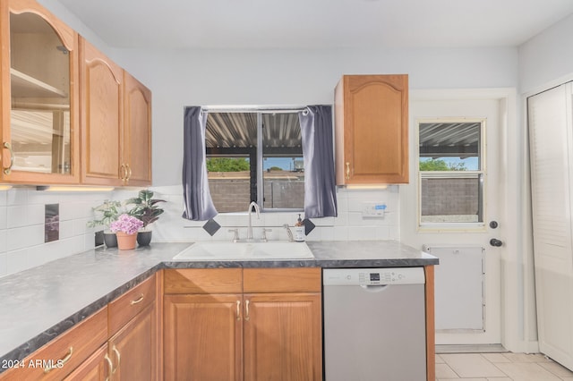 kitchen with sink, dishwasher, decorative backsplash, and light tile patterned floors