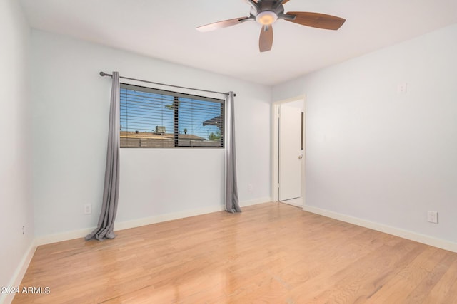 empty room with light wood-style floors, ceiling fan, and baseboards