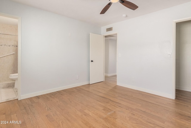 unfurnished bedroom featuring ceiling fan, light wood-type flooring, and connected bathroom