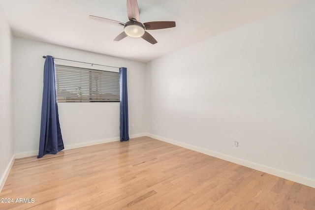 empty room featuring a ceiling fan, light wood-style flooring, and baseboards