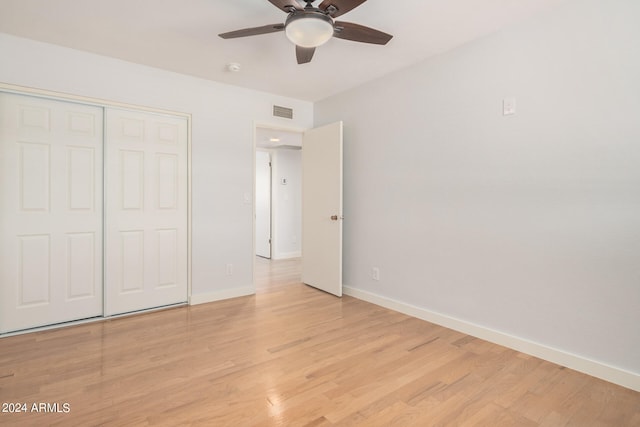 unfurnished bedroom featuring ceiling fan, light hardwood / wood-style flooring, and a closet