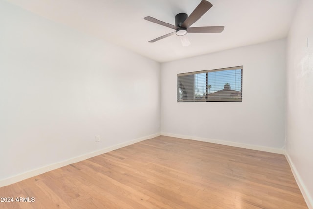 empty room featuring light wood-style floors, ceiling fan, and baseboards