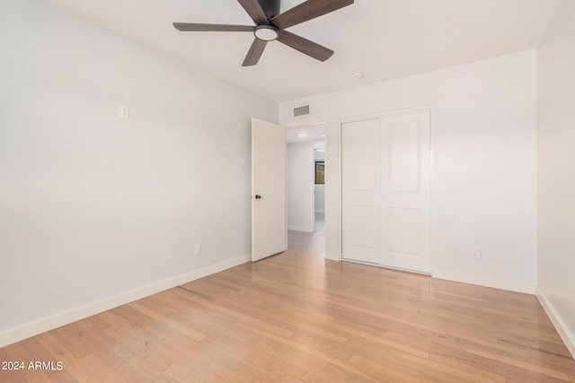 unfurnished bedroom featuring ceiling fan, a closet, and light hardwood / wood-style floors