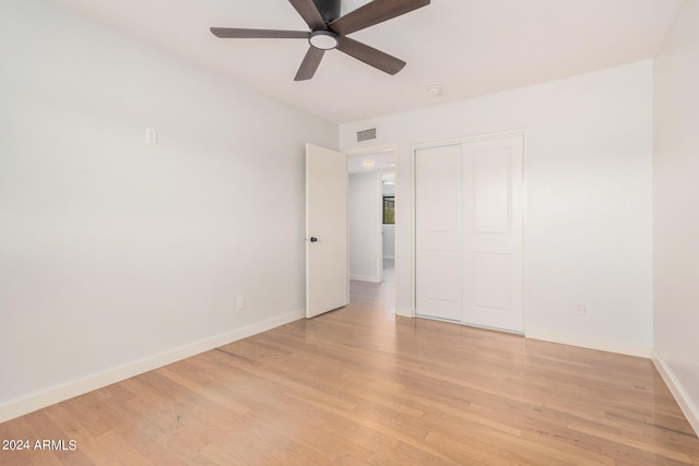 empty room featuring baseboards, ceiling fan, visible vents, and light wood finished floors