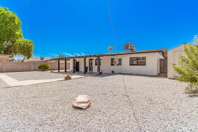 rear view of house with a patio, central AC unit, and a fenced backyard