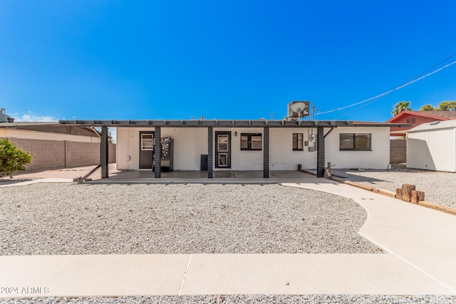 ranch-style home with a storage unit