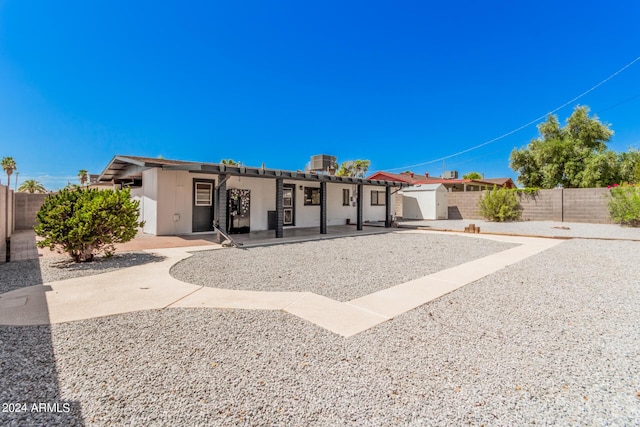 view of front of house featuring a fenced backyard, central AC, and stucco siding