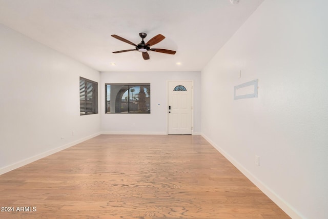 empty room with a ceiling fan, recessed lighting, light wood-style flooring, and baseboards