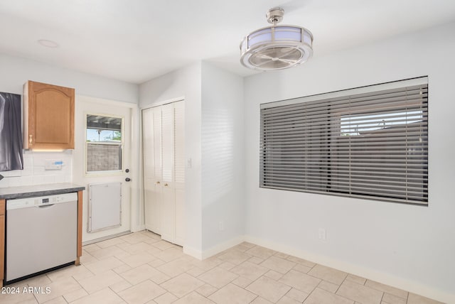 kitchen with light tile patterned floors, decorative backsplash, and white dishwasher