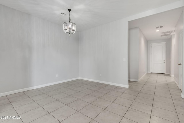 unfurnished room featuring a notable chandelier and light tile patterned floors