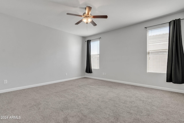 carpeted empty room featuring a wealth of natural light and ceiling fan