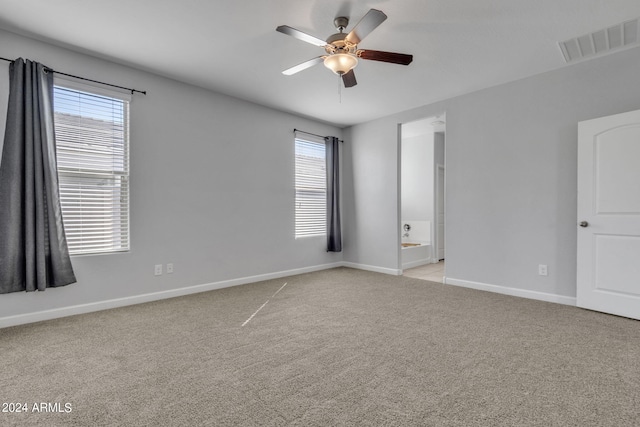 spare room featuring ceiling fan, plenty of natural light, and light colored carpet