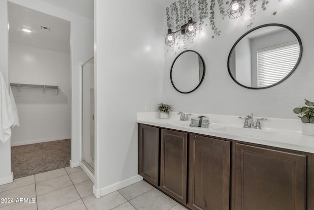 bathroom with tile patterned floors, a shower with door, and vanity