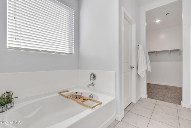 bathroom with a tub to relax in and tile patterned floors