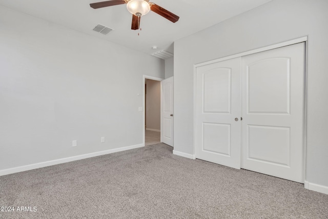 unfurnished bedroom featuring ceiling fan, light colored carpet, and a closet