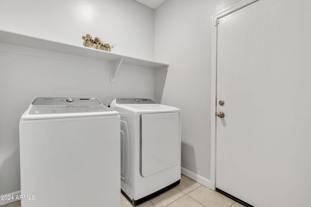 laundry area with independent washer and dryer and light tile patterned floors