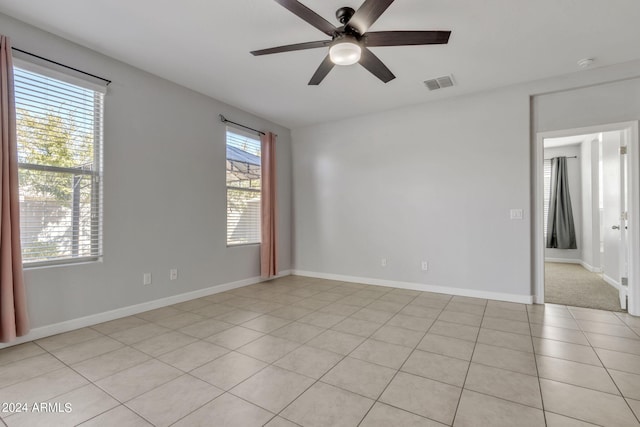 tiled empty room featuring ceiling fan and a wealth of natural light