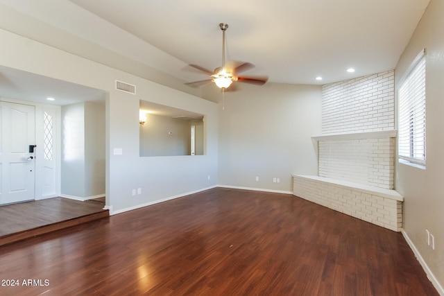 unfurnished living room with ceiling fan, dark wood-type flooring, and a brick fireplace