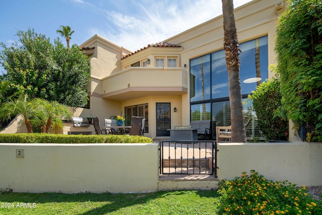 rear view of house featuring a balcony and a patio